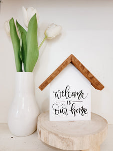 Small rustic house "Welcome to our home" sign